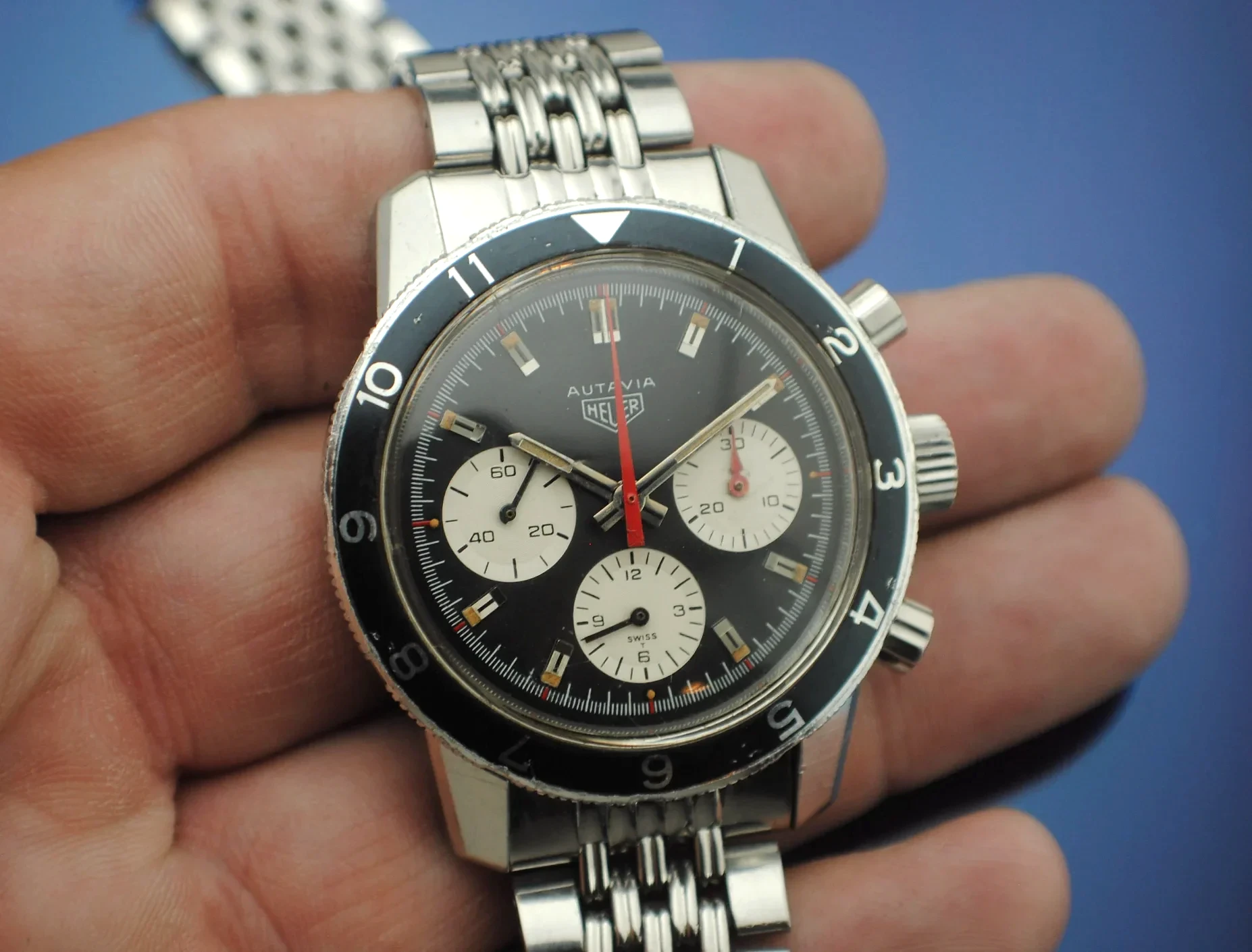 Enhanced close view of the Heuer Autavia dial, three registers, rotating bezel, crown, and pushers