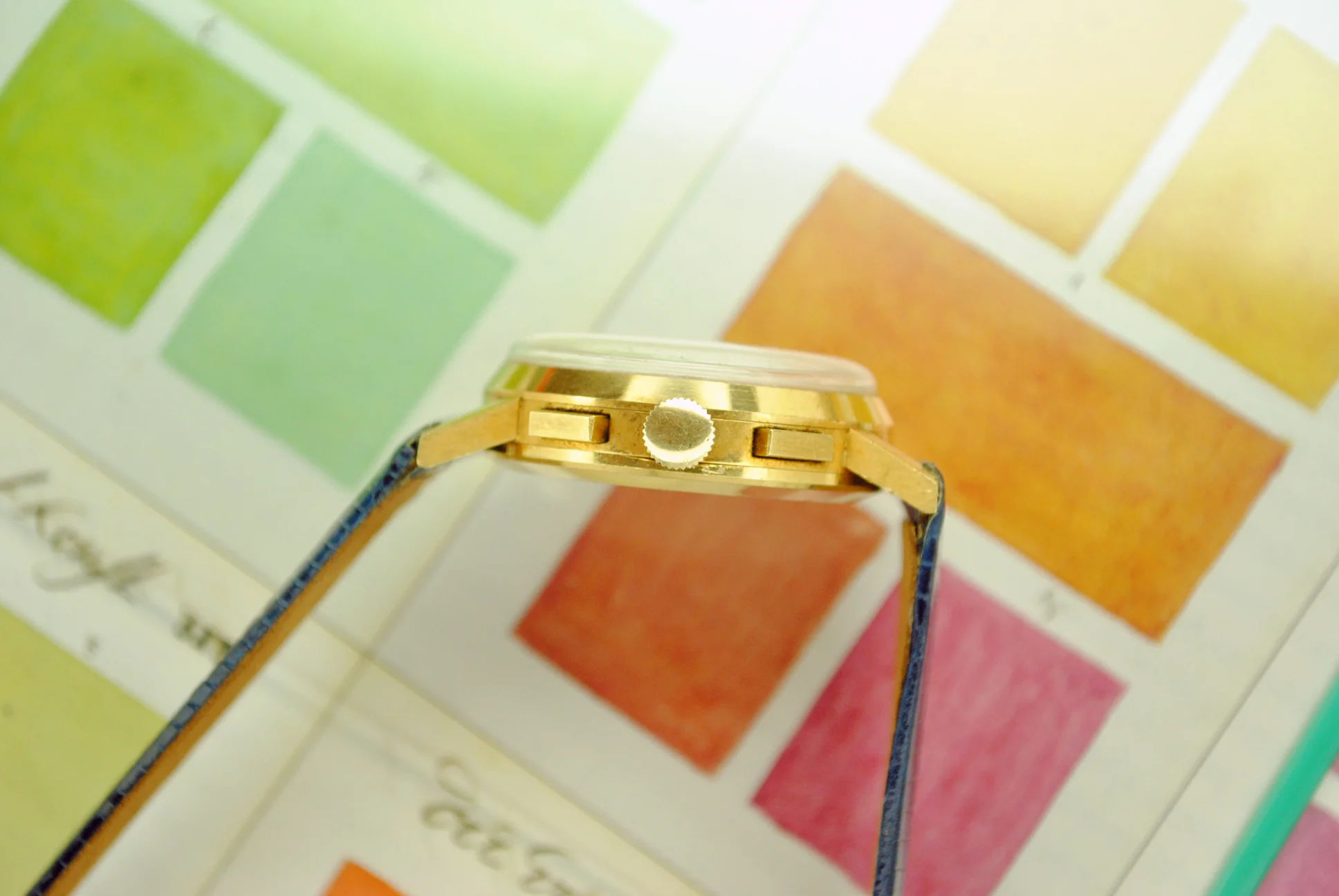 Side profile of the sold Ulysse Nardin rose-gold chronograph showing its crown, rectangular pushers, domed crystal, and lugs