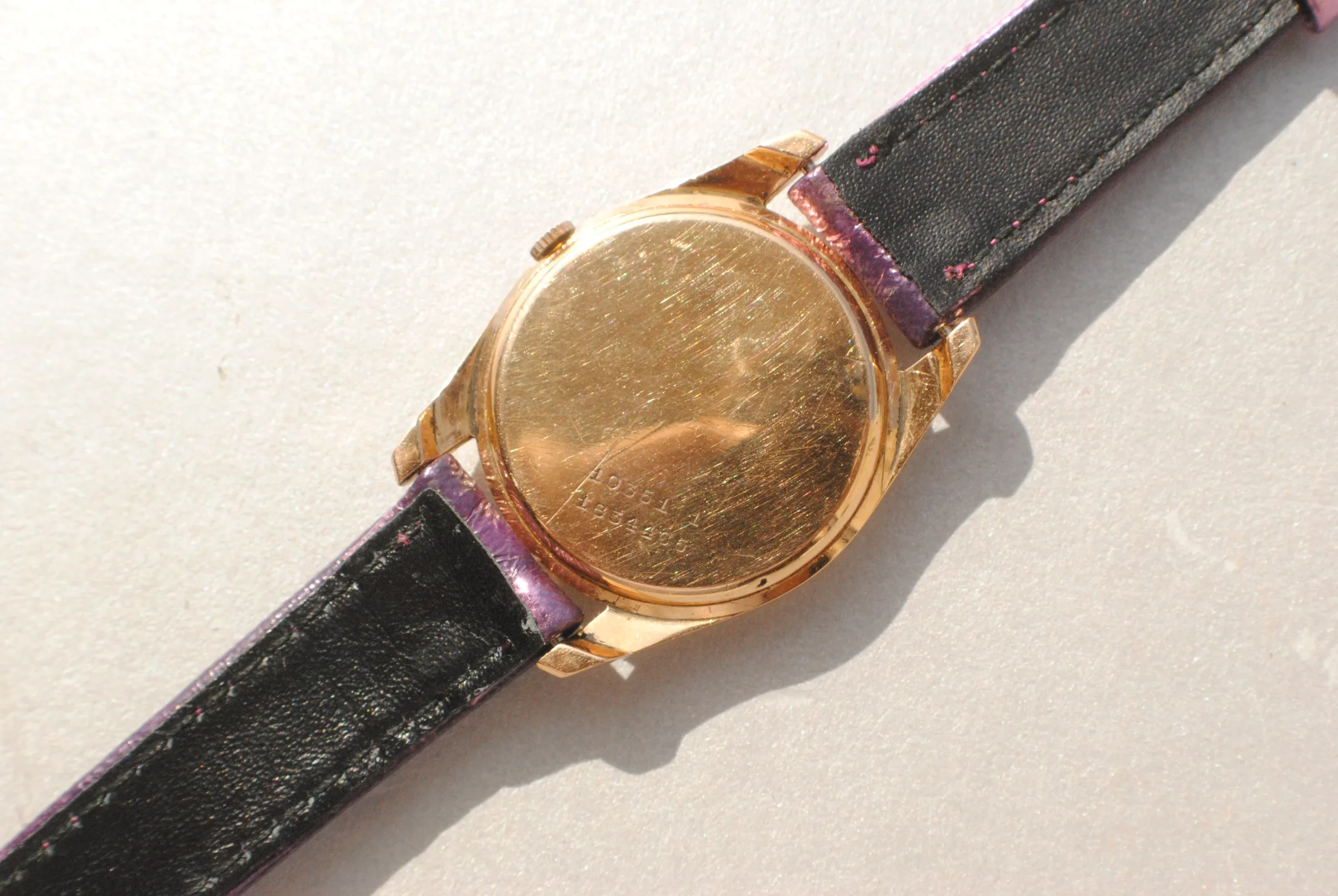 Rear view of the sold Universal Genève reference 10351-1 showing its solid engraved caseback and purple leather strap