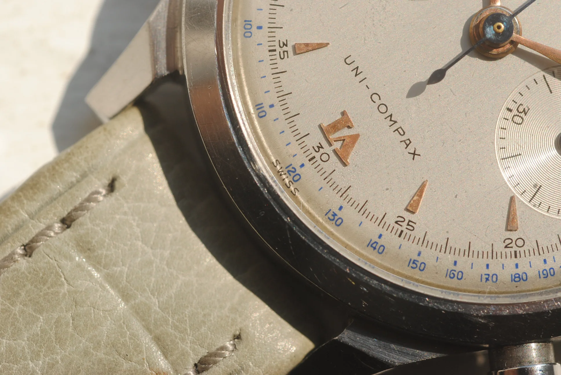 Macro crystal-on dial detail of the sold Universal Genève Uni-Compax chronograph showing applied markers and blue outer scale
