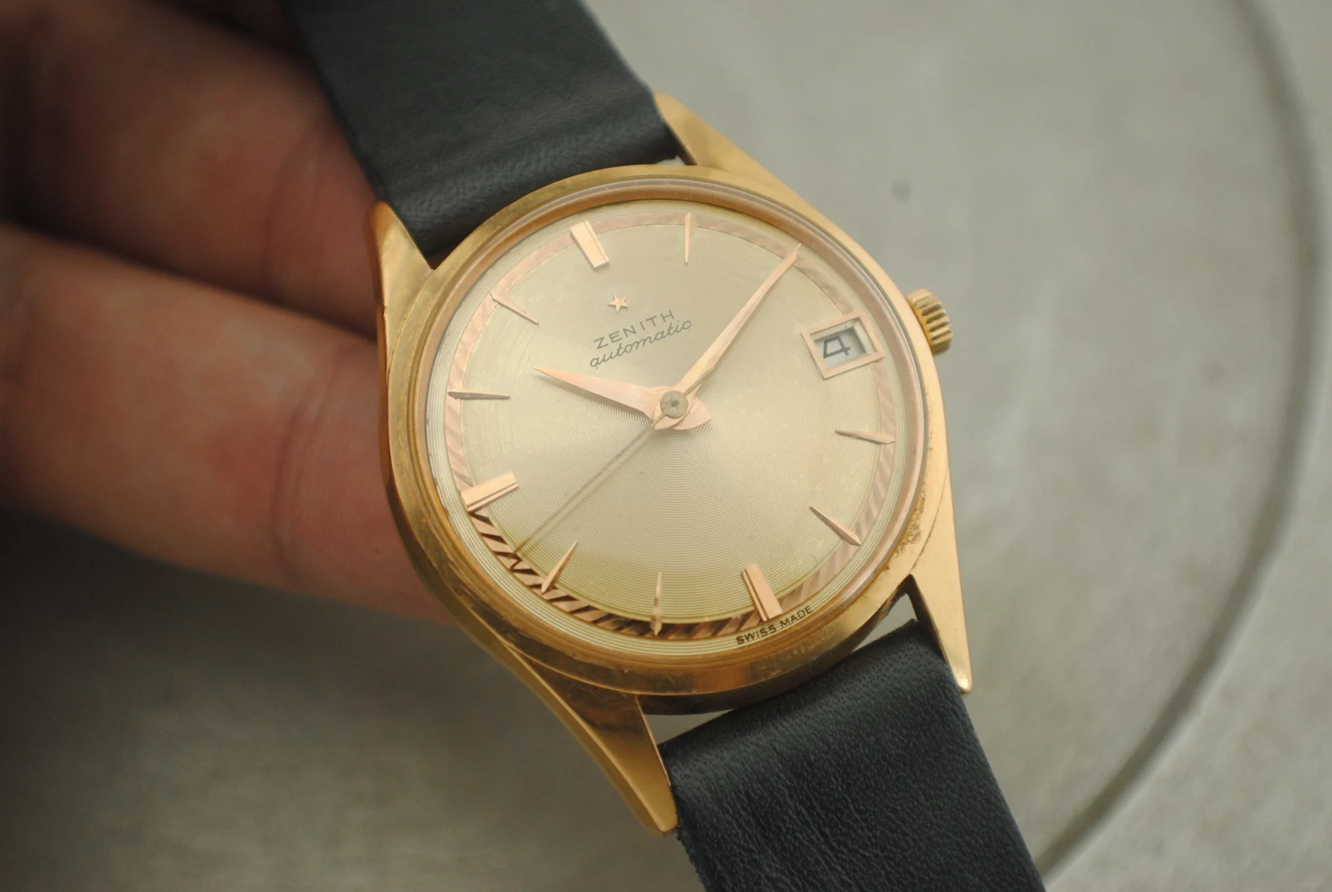Close crystal-on view of the sold Zenith automatic showing its concentric dial, applied markers, and date aperture