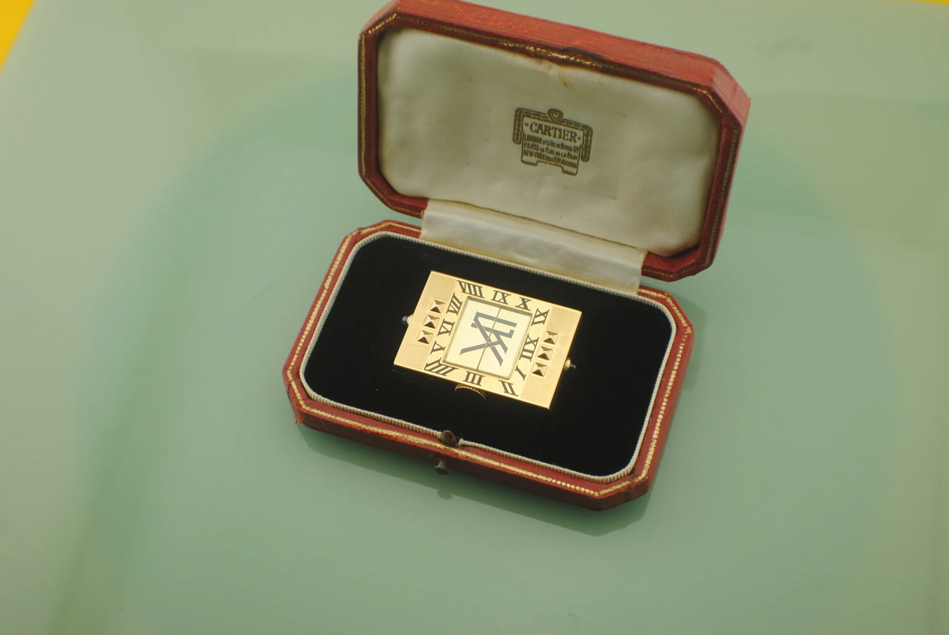 Wider open-box view of the Cartier Guillotine watch resting in its fitted black velvet bed