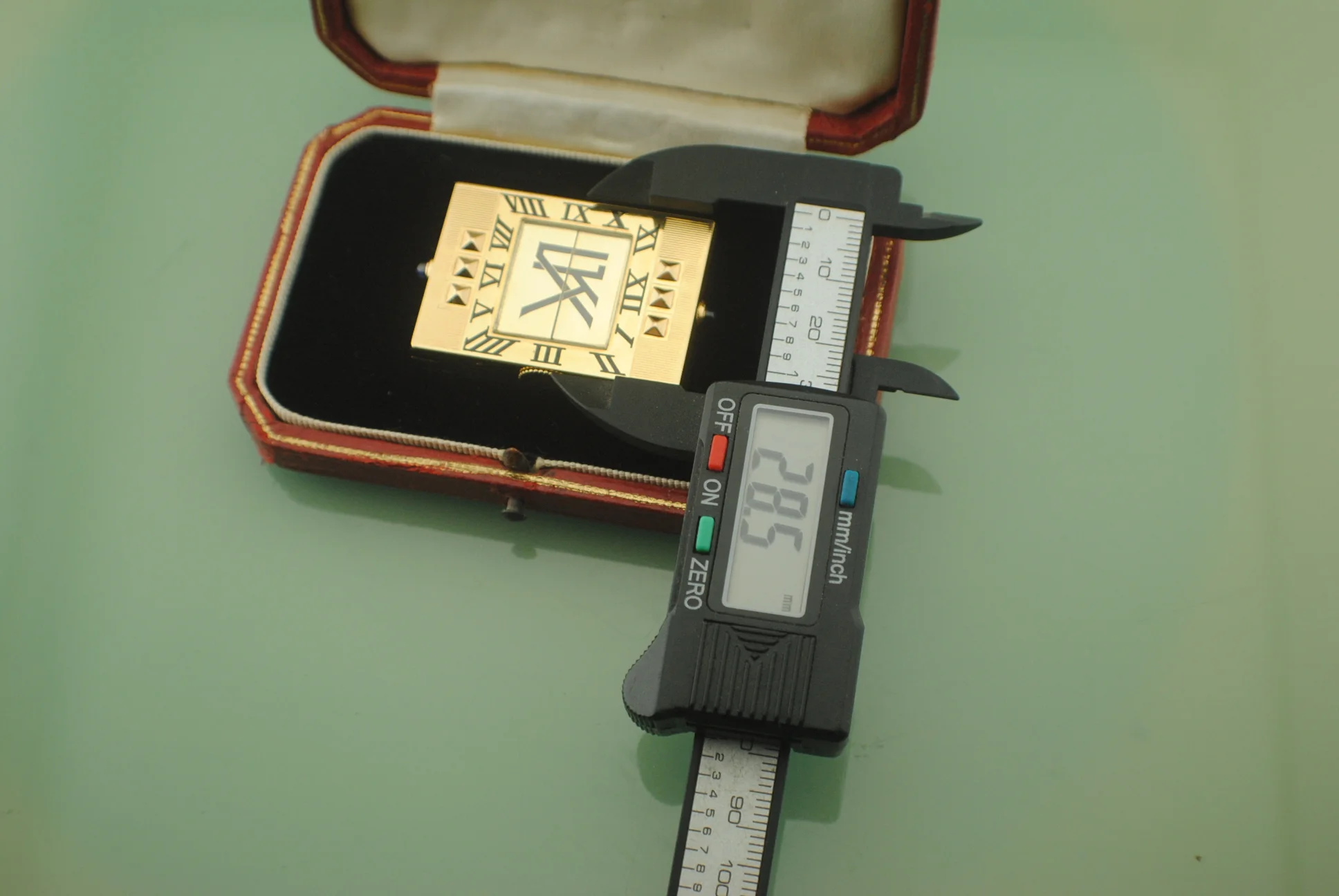 Caliper photograph documenting one dimension of the square Cartier Guillotine watch in its fitted box
